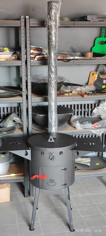 Печь для казана 12 л с дымоходом, заслонкой, зольником, вытяжным отверстием, ручками, складными ножками, двумя металлическими полками по бокам и крышкой.